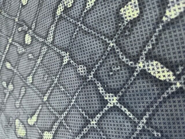 Close-up of batik wax lines on cross-stitched fabric