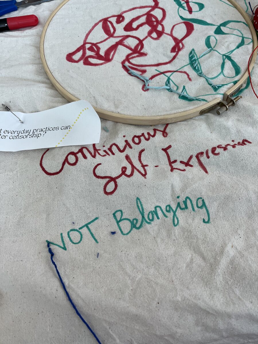 Embroidered words &lsquo;continuous self-experiencing&rsquo; and &lsquo;not belonging&rsquo; on fabric
