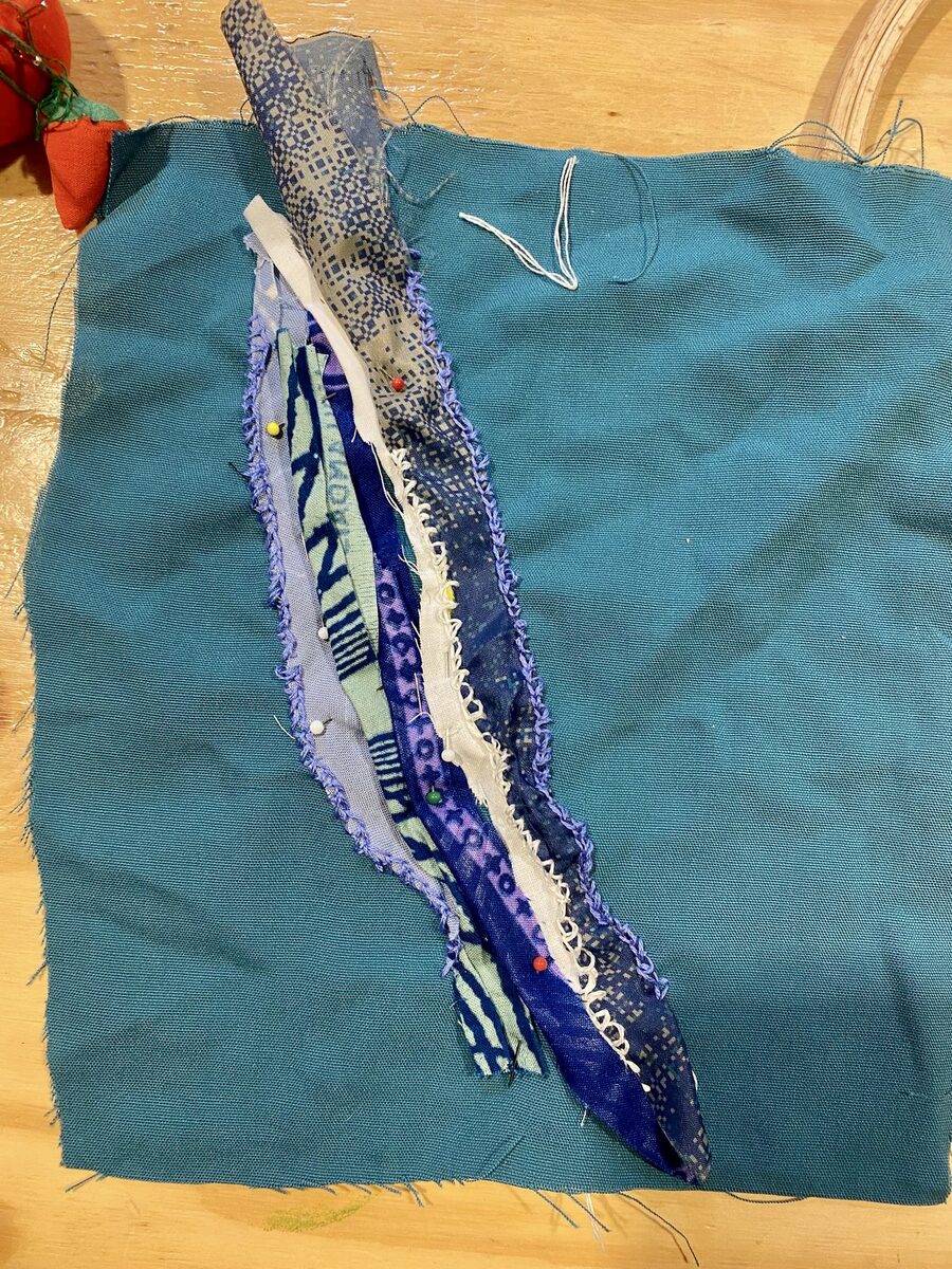 Teal fabric pocket with layered stitched appliqu&eacute;