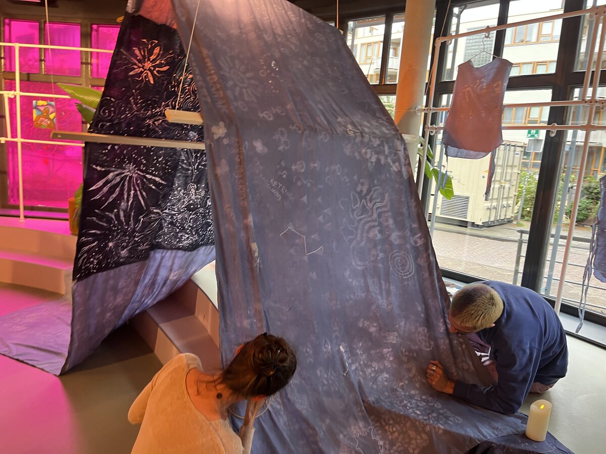 Visitors embroidering their stories onto the tent